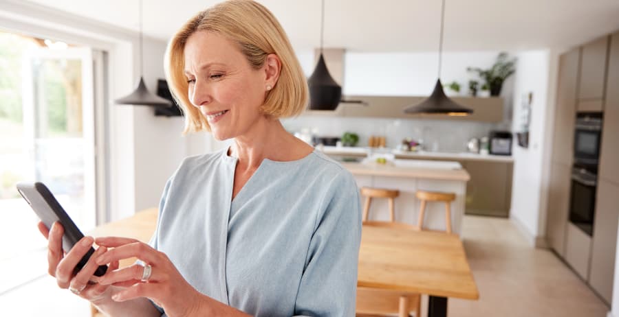 Resident holding a smartphone in a stylish home
